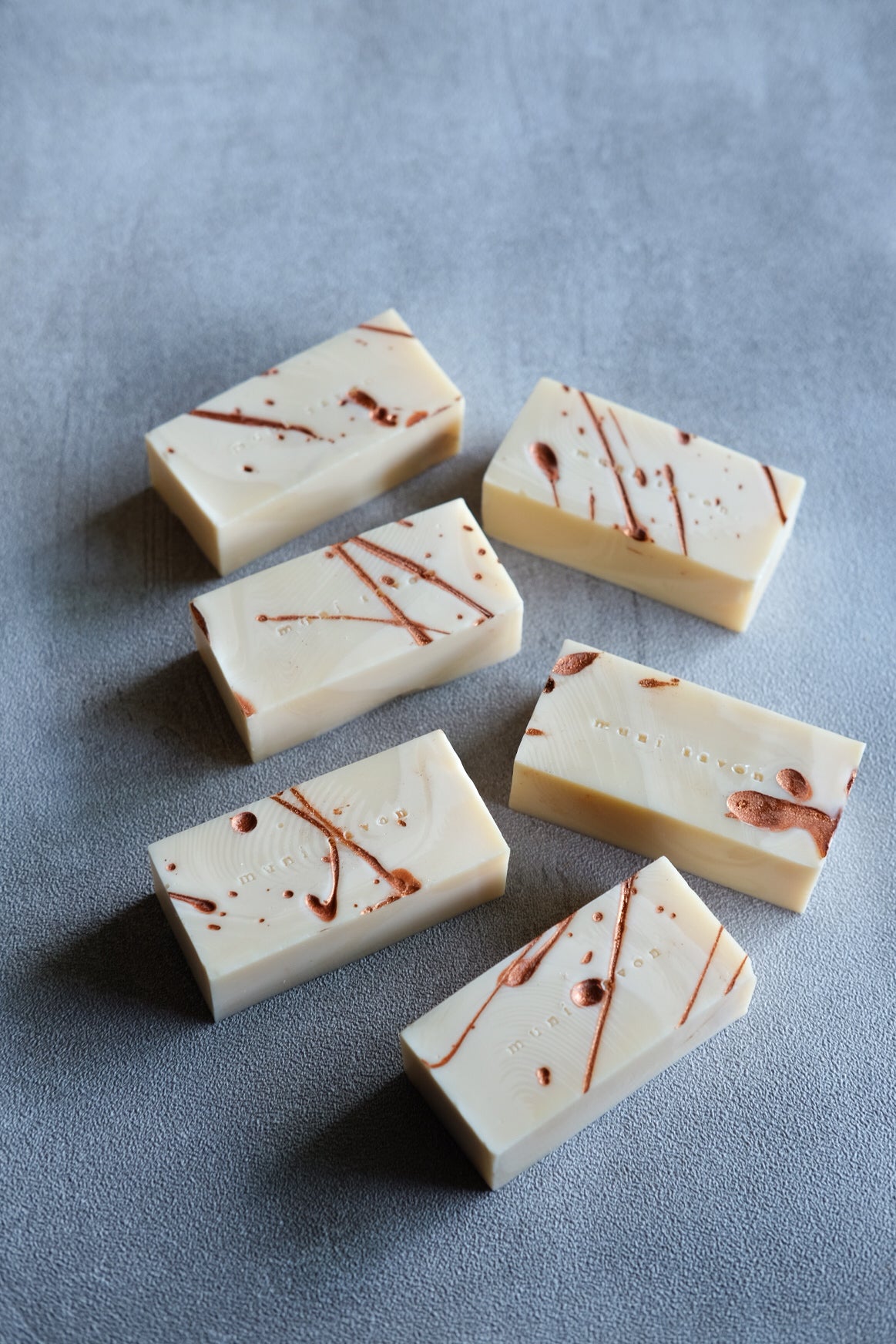 Artisan cold process soap with flowing copper markings and sculptural texture