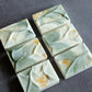 Handcrafted soap with flowing fold textures and subtle gold details