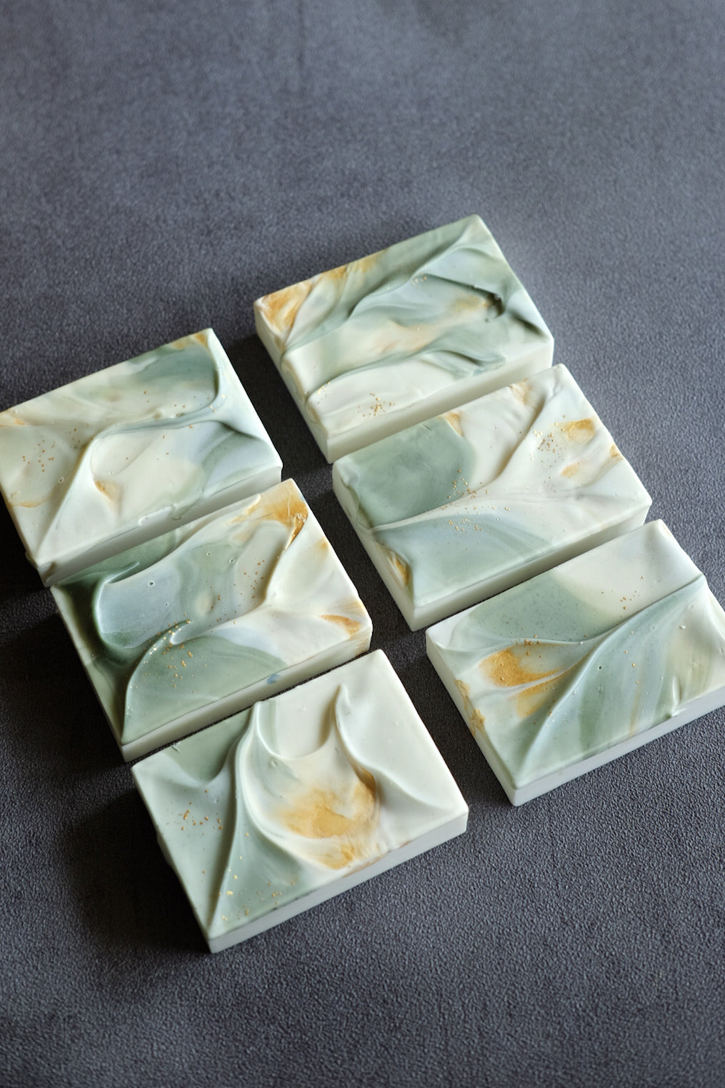 Handcrafted soap with flowing fold textures and subtle gold details