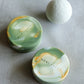 Artisan round soap with fluid marble textures and gold accents