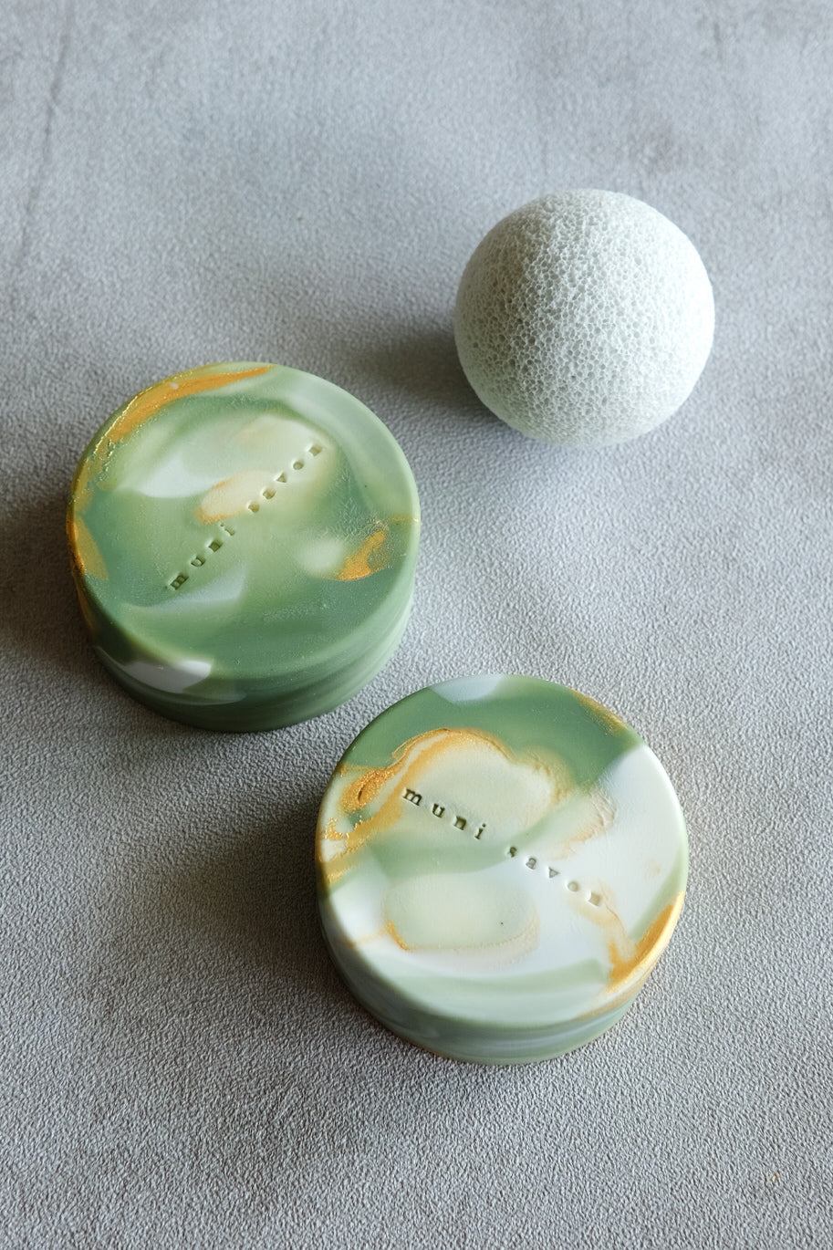 Artisan round soap with fluid marble textures and gold accents